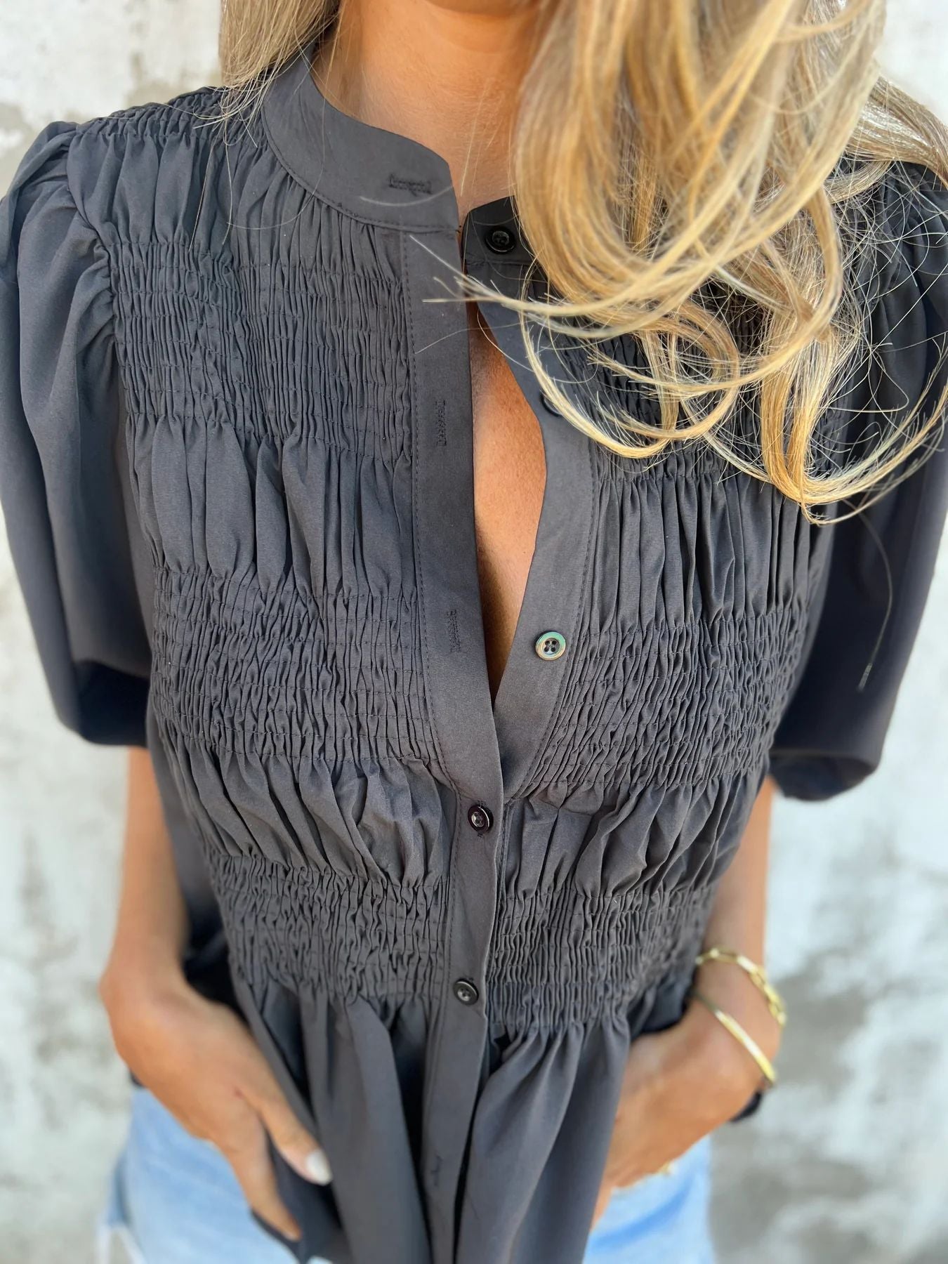 Women's pleated shirt with a round neckline and buttons