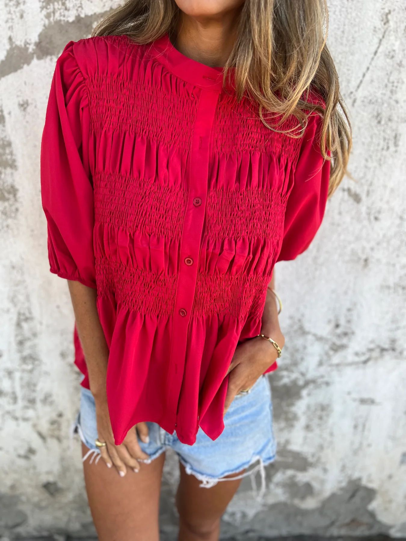 Women's pleated shirt with a round neckline and buttons
