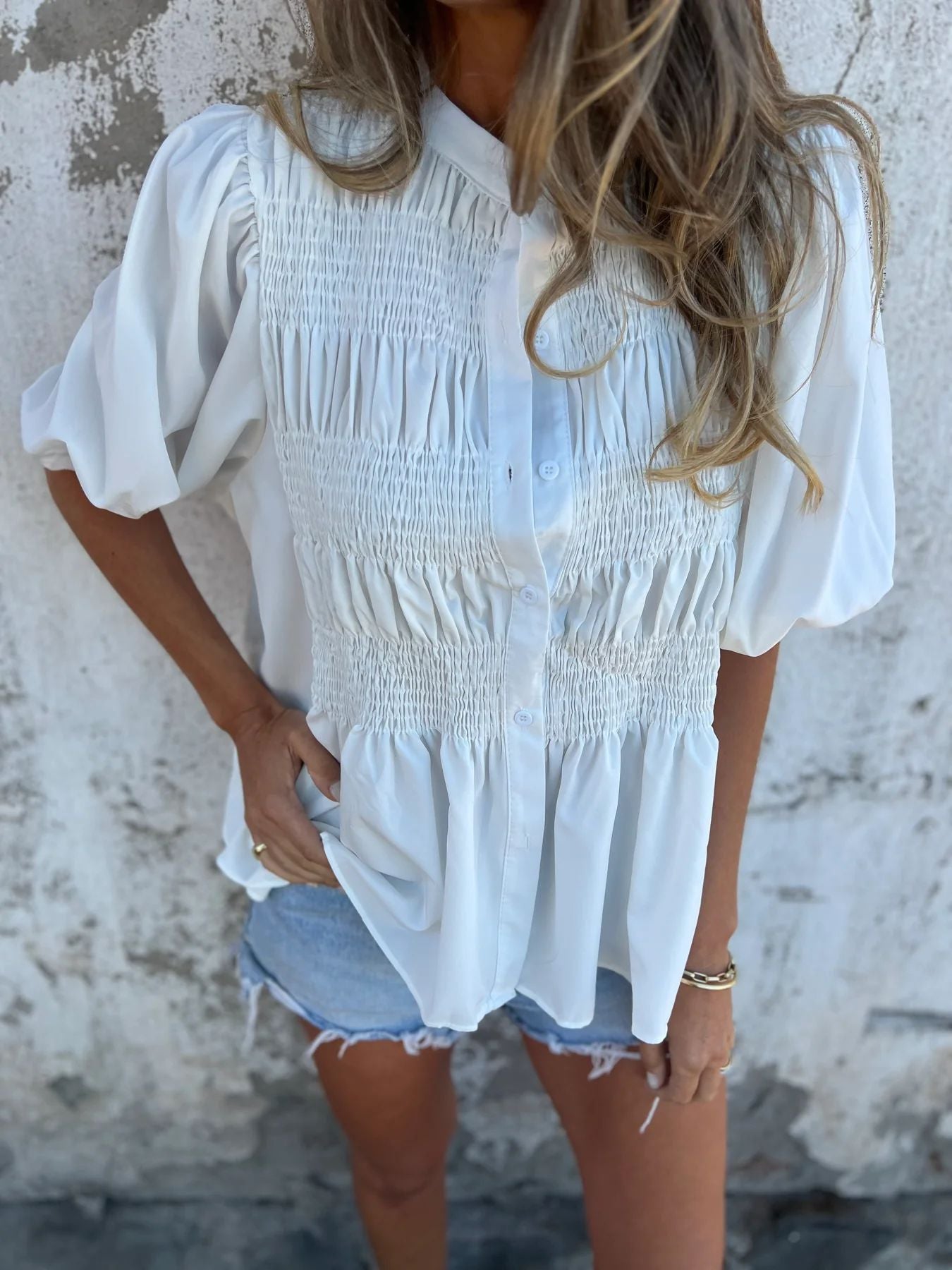 Women's pleated shirt with a round neckline and buttons