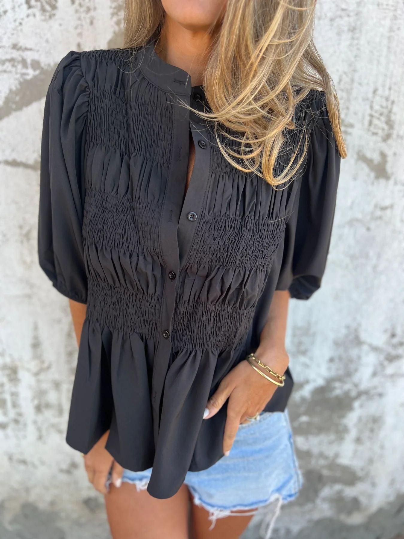 Women's pleated shirt with a round neckline and buttons