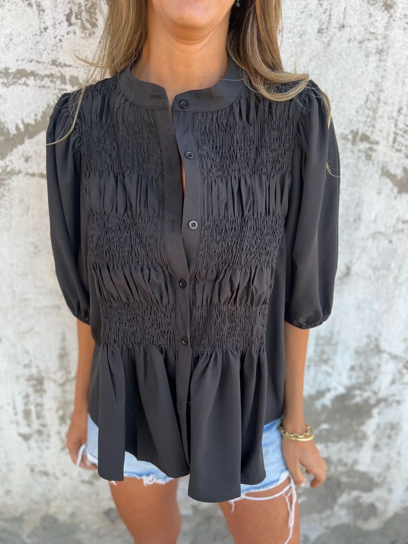 Women's pleated shirt with a round neckline and buttons
