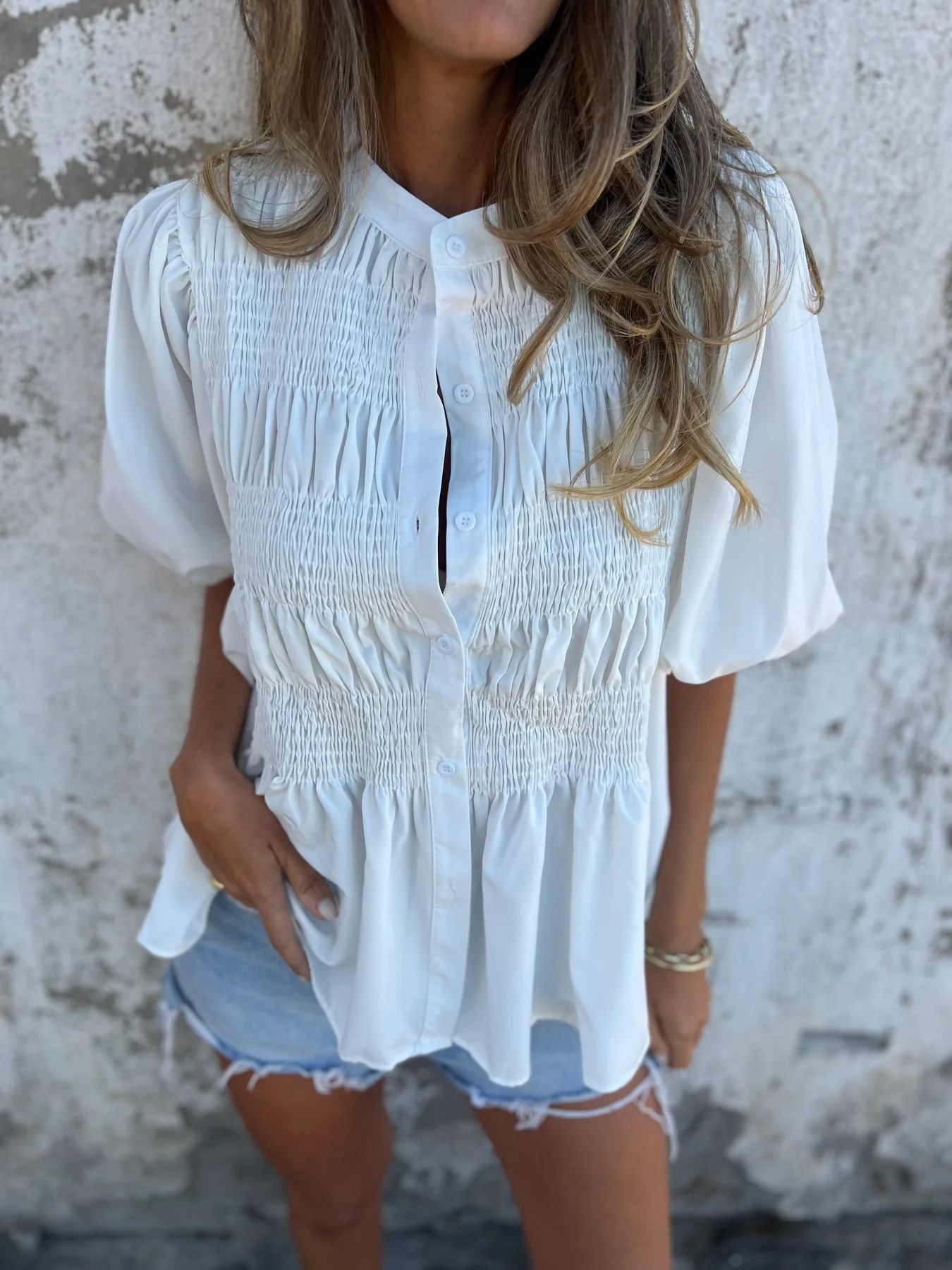 Women's pleated shirt with a round neckline and buttons