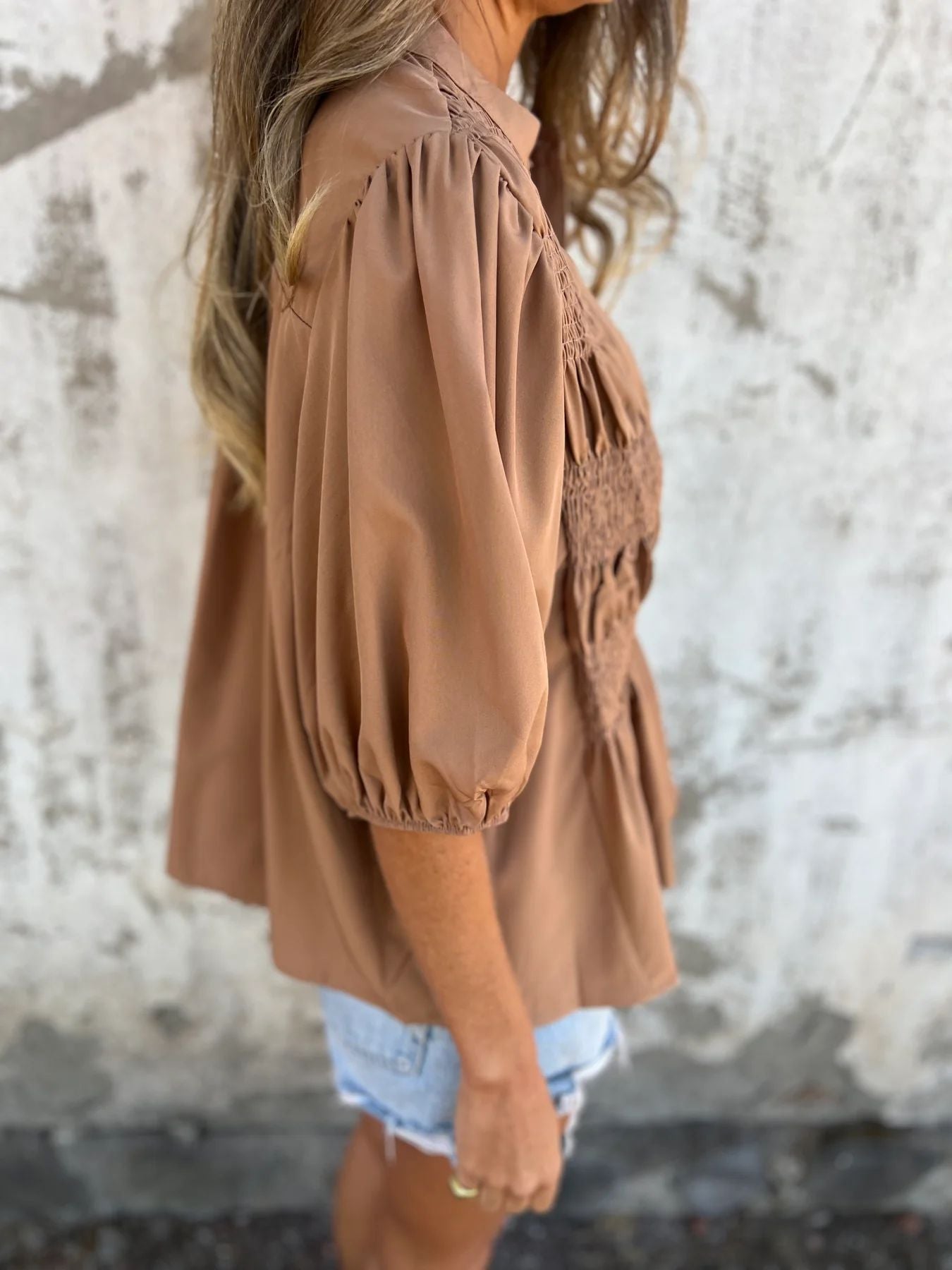 Women's pleated shirt with a round neckline and buttons