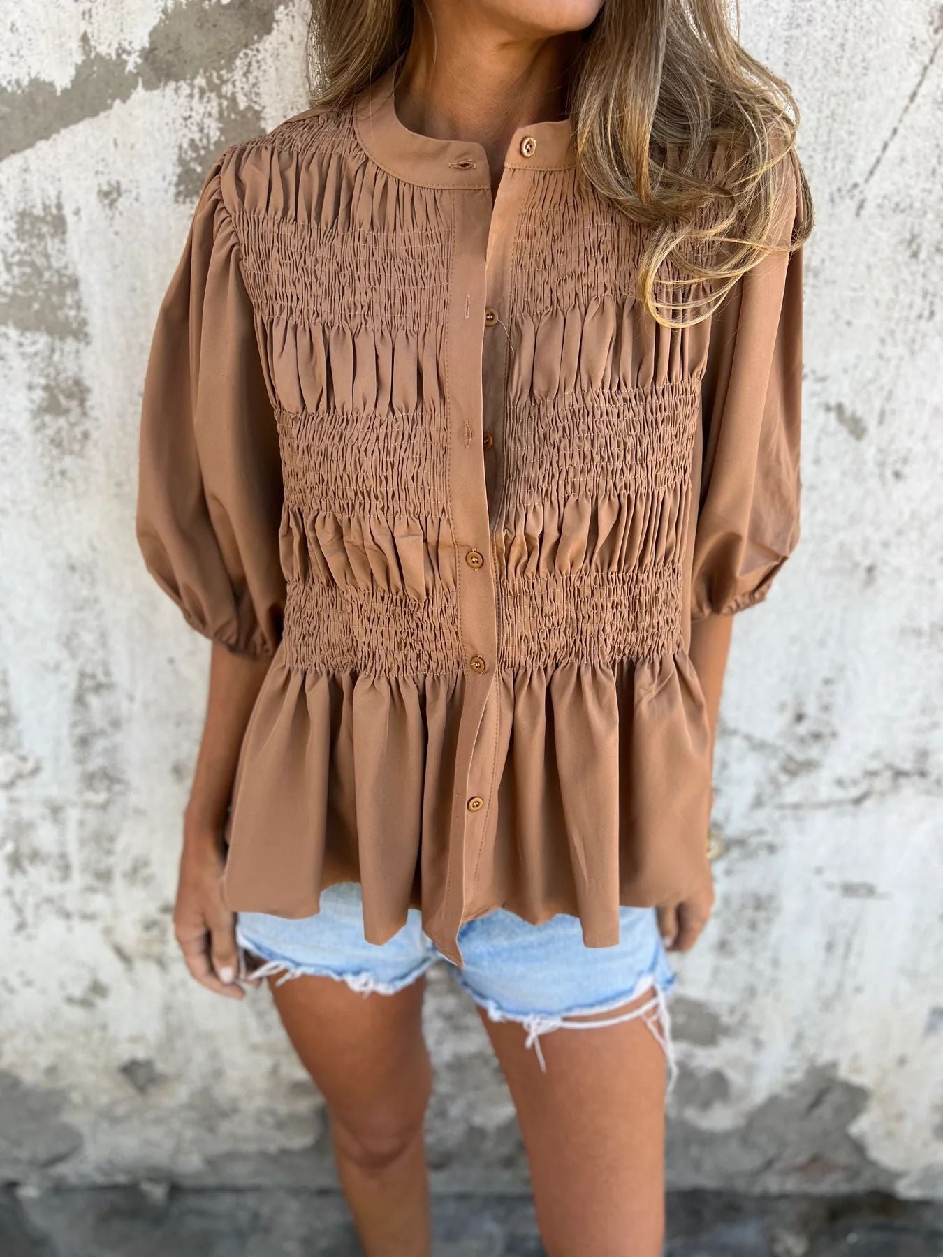 Women's pleated shirt with a round neckline and buttons