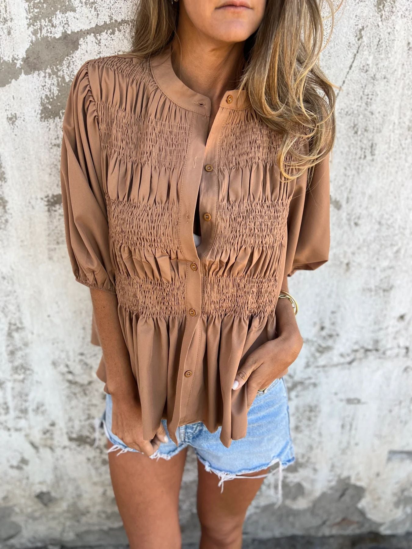 Women's pleated shirt with a round neckline and buttons